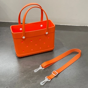Detail view of orange EVA beach bag with holes, matching shoulder strap and white button accents