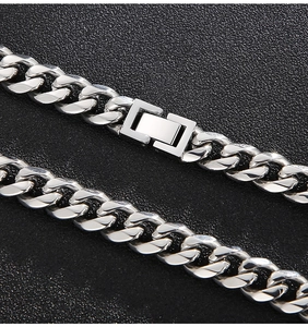 Macro shot of 10mm polished silver stainless steel Cuban link chain with rectangle clasp
