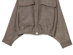 Detail of herringbone pattern texture and flap pockets on a brown bomber jacket