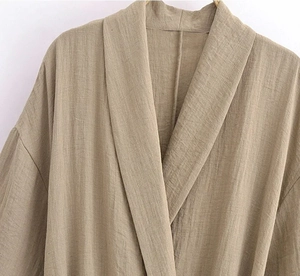 Close-up of khaki cotton linen fabric texture and kimono collar design details