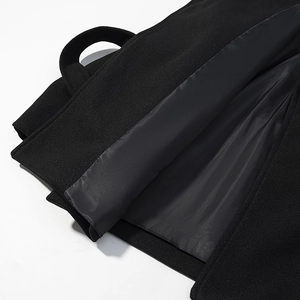 Detail view of black wool-like coat fabric with smooth silk-texture inner lining