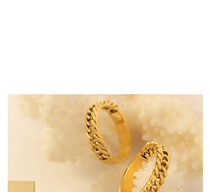 Close-up of golden double-layer snake chain ring displayed on a white coral texture