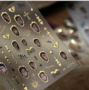 Macro detail of Halloween nail stickers with gold embossed ghosts and bat patterns
