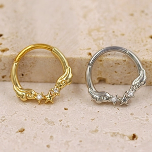 Detailed view of gold and silver nose rings with star and wing designs on stone