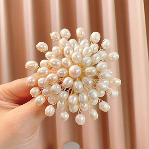 Macro shot of handcrafted natural freshwater pearl brooch with radiating woven design