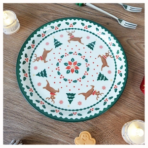 Christmas ceramic plate with reindeer and tree patterns on a rustic wooden table surface