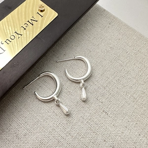 Minimalist S925 sterling silver frosted drop earrings on light grey fabric background
