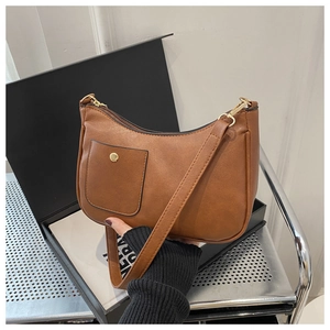 Detail of vintage brown PU leather square bag with golden snap button on front pocket