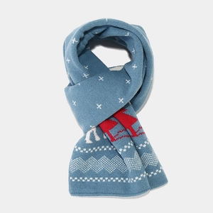 Detail of knitted winter scarf with festive blue and red reindeer snowflake patterns