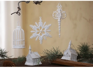 White frosted Christmas ornaments with snowflake and vintage cage hung on branches