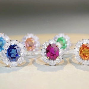 Macro shot of halo-set floral silver rings featuring vibrant multi-colored gemstones