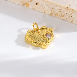 Macro shot of gold irregular heart charm with Love engraving and zircon on stone base