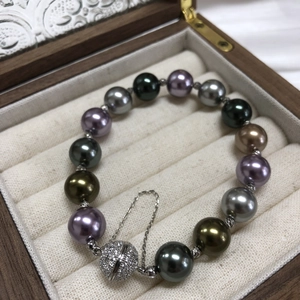 Close-up of multicolor Morandi pearls and silver pave zircon magnetic clasp in a box