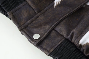 Macro detail of animal print jacket featuring a silver snap button and elastic cuff
