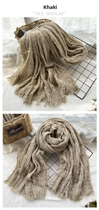 Detailed macro view of khaki scarf with wrinkled texture and frayed edge tassels