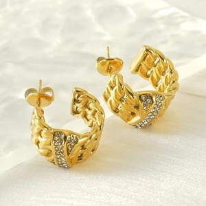 Golden titanium steel twist hoop earrings with pavé crystal accents in a C-shape design
