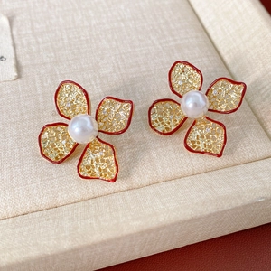 Nahaufnahme vintage roter Blumenohrstecker mit hohlen Blütenblättern und einer Perle