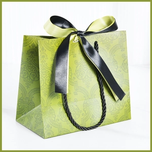 Green gift paper bag with vintage floral patterns and a decorative silk ribbon bow