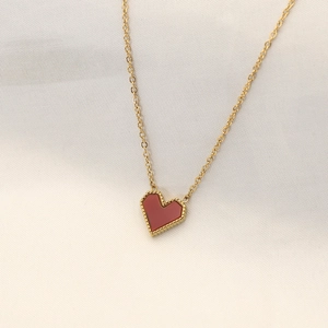 Macro shot of 18k gold plated necklace featuring a red heart pendant with bead edges