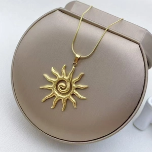 Vintage golden sunflower necklace with spiral texture on a beige jewelry display box