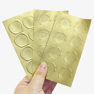 Golden embossed wax seal stickers with floral designs and text on white background