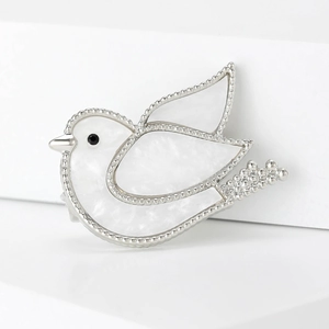 Elegant silver-toned dove brooch with white shell inlay and beaded edges for suits