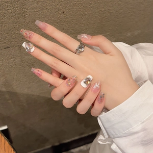 Nude pink press-on nails with 3D butterflies and rhinestones for a bridal manicure