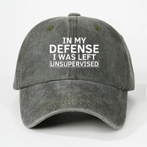 Detail of washed grey cotton baseball cap with white slogan text on a clean white background