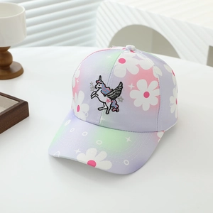 Dettaglio del ricamo a unicorno e motivi floreali sul cappellino sfumato da bambino