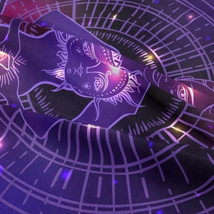 Macro detail of the celestial sun pattern on a purple mystical tapestry fabric