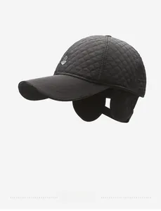 Side view detail of quilted black baseball cap with ear flaps and metal shield emblem