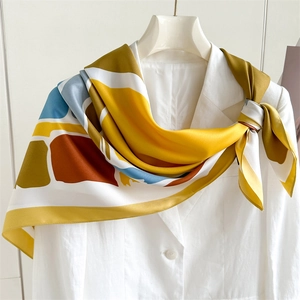 Luxurious geometric print silk scarf 90x90cm on white suit jacket for fashion styling