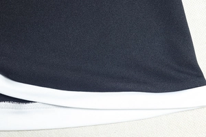 Dettaglio del tessuto a maglia ad alta densità e cuciture a contrasto bianco e nero