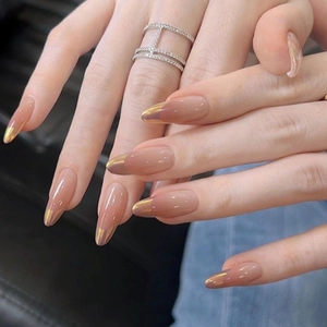 Nude pink almond press-on nails with sunset gold chrome french tips on hands