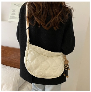 Quilted white half-moon crossbody bag with a khaki strap and cute rabbit plush charm