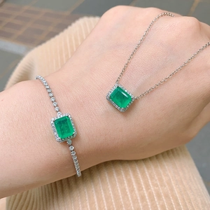 Close-up of model wearing silver jewelry set with green emerald-cut stones