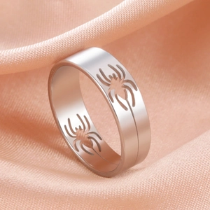 Spider web cutout stainless steel ring in silver finish on soft pink silk background
