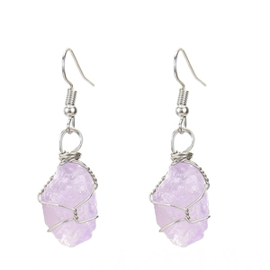 Detail of silver wire-wrapped purple raw amethyst crystal drops with natural stone texture