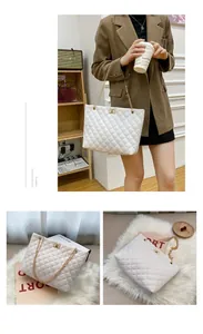 Close-up of white quilted tote bag featuring golden chain straps and elegant metal lock