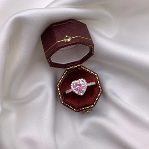 Close-up of a pink heart gemstone ring with pavé diamonds in a red octagonal gift box