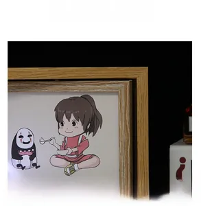 Détail du cadre rotatif en bois avec finition grainée et illustration Ghibli