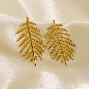 Minimalist 14K gold leaf stud earrings with palm feather texture on beige silk