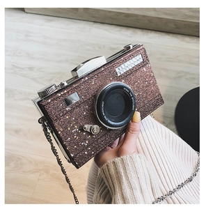 Close-up of brown glitter camera bag with star patterns and a gold chain strap