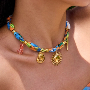 Bohemian woven necklace featuring a gold cowboy hat pendant and colorful beads on model