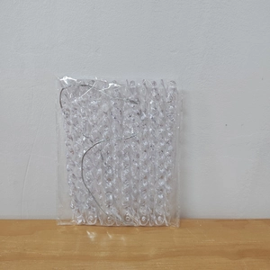 Close-up of clear acrylic Christmas icicle ornaments in packaging with silver string