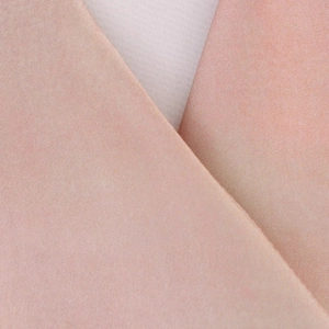 Vue macro d'un tissu tie-dye rose clair montrant la texture suède et les détails fins