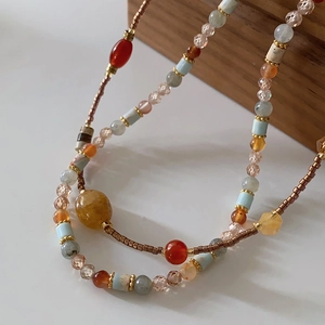 Ethnic beaded necklace with red agate, blue tube beads and vintage style metallic accents