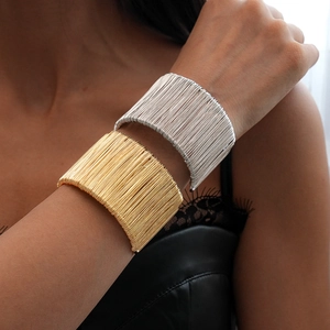 Minimalist geometric wire-wrapped open cuff bracelet in polished gold and silver finishes