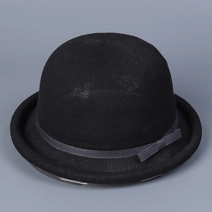 Detail of knitted dome hat with grey striped ribbon and bow, showing woven texture