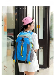 Detailed rear view of a blue large capacity hiking backpack on an Asian female model